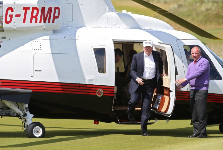US presidential candidate Donald Trump, second right, arrives by helicopter for a tour at the Trump International Golf Links at Balmedie, near Aberdeen, Scotland, Saturday June 25, 2016.  Presidential hopeful Donald Trump is on a short break away from his presidential campaign. (Andrew Milligan / PA via AP) 