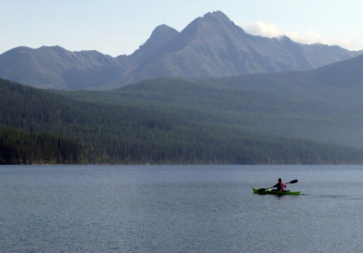 FILE - In this Sept. 6, 2013, file photo, Ingrid Forsmark kayaks on Kintla Lake in Glacier National Park, Mont. The Obama administration on Thursday, March 17, 2016, canceled a disputed oil and gas lease just outside Glacier National Park that is on land considered sacred to the Blackfoot tribes of the U.S. (AP Photo/Matt Volz, File)