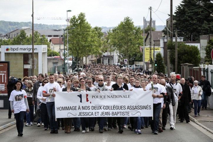 Police officers and residents walk with a banner reading "Homage to the two slain colleagues Jessica and Jean-Baptiste" during a white march in Mantes-la-Jolie, west of Paris, Thursday, June 16, 2016. French police officials Jean-Baptiste Salvaing and his companion Jessica Schneider were killed Monday by an Islamic State extremist. (AP Photo/Kamil Zihnioglu)