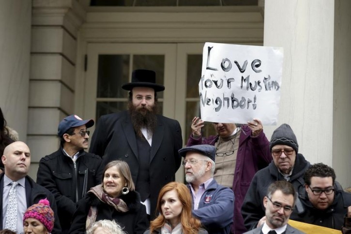 FILE - People opposed to Republican presidential Donald Trump's proposal to ban Muslims from entering the United States stand on the steps of New York's City Hall during an interfaith rally in Manhattan December 9, 2015. Reuters