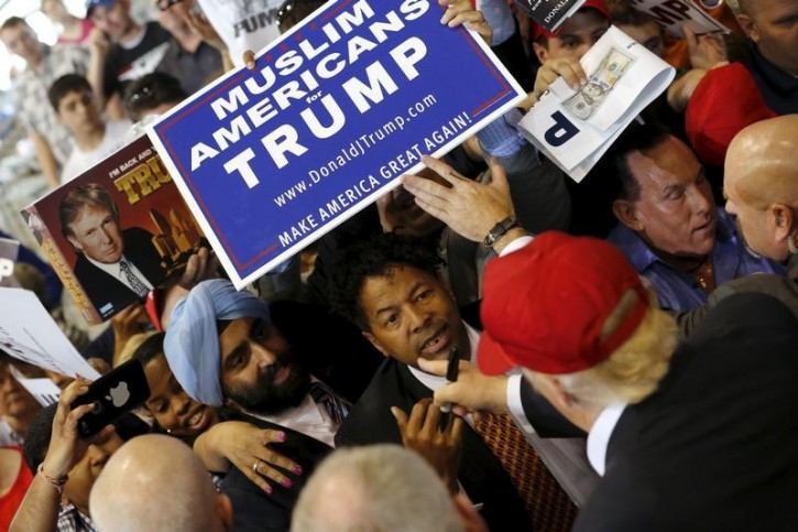 U.S. Republican presidential candidate Donald Trump signs autographs for supporters holding a Muslim Americans for Trump sign after a rally in Harrington, Delaware April 22, 2016. REUTERS/Jonathan Ernst -