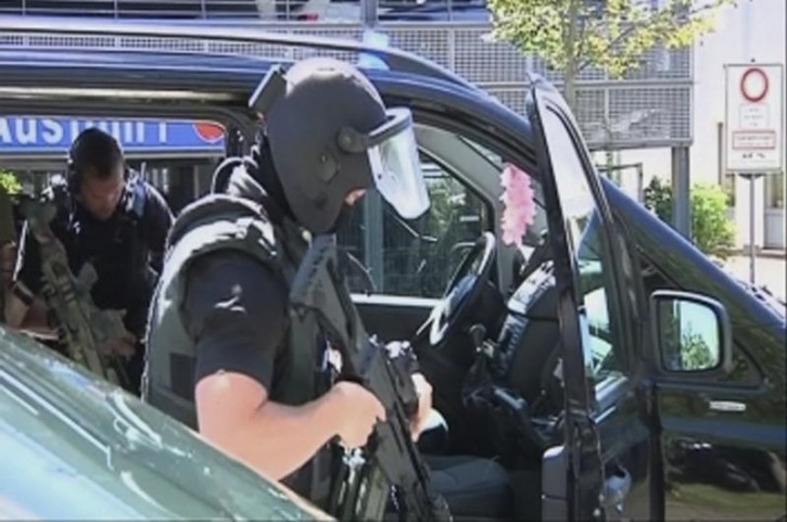 German special police leave their cars in this still image taken from video after a masked man with a gun and ammunition belt opened fire in a cinema complex in the small western town of Viernheim, near Frankfurt, Germany, June 23, 2016, injuring several people and barricaded himself inside the building.       REUTERS/Rhein-Neckar-Fernsehen via REUTERS TV -