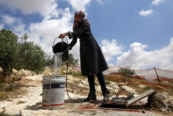 FILE - A member of the al-Hamadeh family fills water from a well outside a cave they use as their home on the outskirts of the West Bank village of Mufagra, in Yatta, 80 kilometers south of Hebron, 14 April 2016. EPA