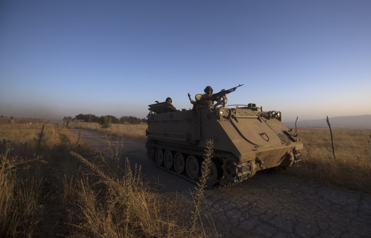  Israeli soldiers driving their Armored Personnel Carriers (APCs) at sunset during a training exercise in the Golan Heights, near the Israel border with Syria on 27 June 2016.  EPA/ATEF SAFADI