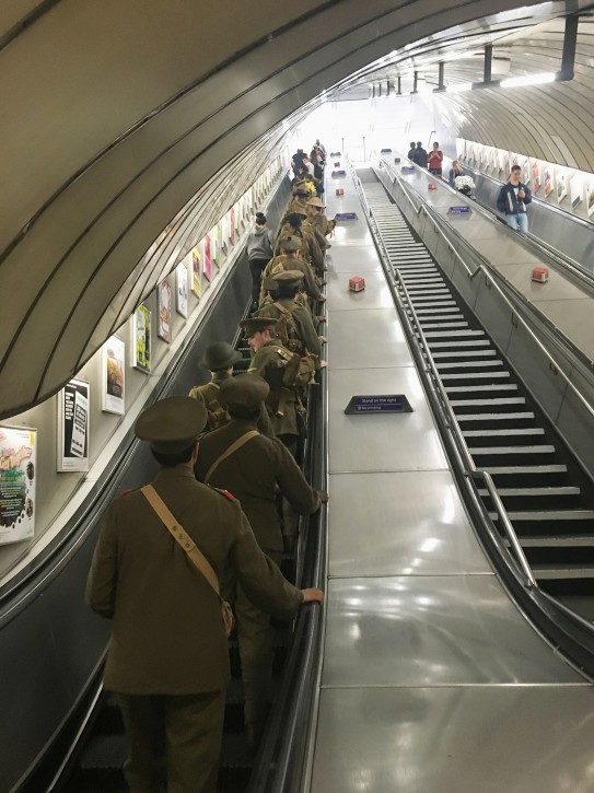 Men dressed as First World War soldiers stand on an escalator as they leave Euston underground station in London, to mark 100-years since the start of the Battle of the Somme, early Friday July 1, 2016. London commuters were met by the eerie sight of people dressed as World War I soldiers as they made their way to work Friday, with the soldiers singing wartime songs or remaining silent, revealed later Friday as a Somme tribute, the work of Turner Prize-winning artist Jeremy Deller, National Theatre Director Rufus Norris and thousands of volunteers. (Sarah Perry / PA via AP)