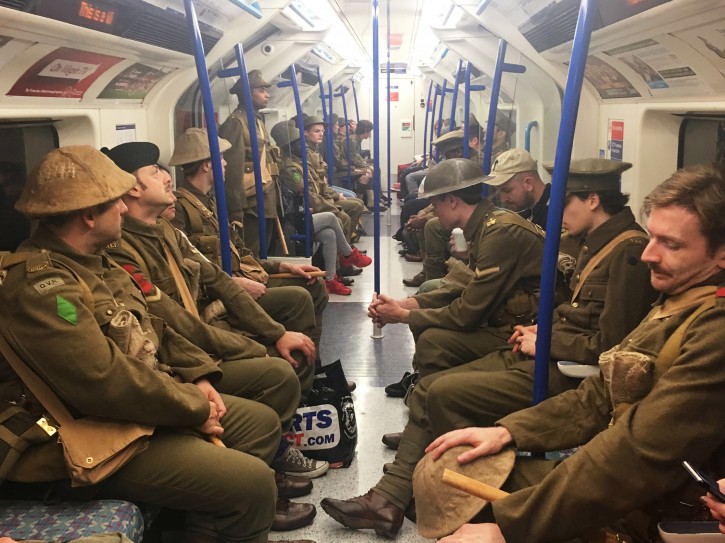 Men dressed as First World War soldiers mingle with regular commuters aboard an underground tube train in London, to mark 100-years since the start of the Battle of the Somme, early Friday July 1, 2016. London commuters were met by the eerie sight of people dressed as World War I soldiers as they made their way to work Friday, with the soldiers singing wartime songs or remaining silent, revealed later Friday as a Somme tribute, the work of Turner Prize-winning artist Jeremy Deller, National Theatre Director Rufus Norris and thousands of volunteers. (Sarah Perry / PA via AP)