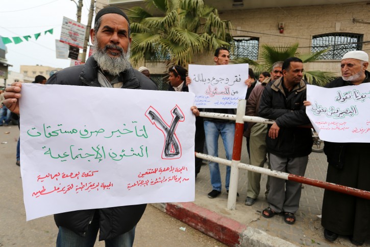 FILE - Palestinians with low income take part in a demonstration calling the Ministry of social affairs to pay their allocations and providing social assistance, in Rafah in the southern Gaza Strip, on February 15, 2015.  Flash90