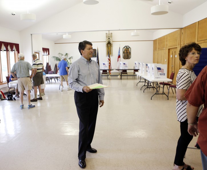 FILE - In this June 28, 2016 file photo, Republican candidate John Faso waits to scan his ballot while voting in the New York congressional primary election at St. Paul's Episcopal Church in Kinderhook, N.Y.  Democrat Zephyr Teachout and  Faso expect an expensive and hard-fought battle for a congressional seat opening in New York with the retirement of Republican U.S. Rep. Chris Gibson. (AP Photo/Mike Groll, File)