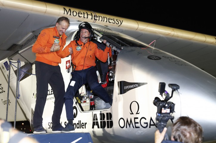 Bertrand Piccard, right, and Andre Borschberg, left, the pilots of the Solar Impulse 2 plane, celebrate in Abu Dhabi, United Arab Emirates, Tuesday, July 26, 2016. The world's first round-the-world flight to be powered solely by the sun's energy made history on Tuesday as it landed in Abu Dhabi, where it first took off on an epic 25,000-mile (40,000-kilometer) journey that began more than a year ago. (Peter Klaunzer/Keystone via AP)