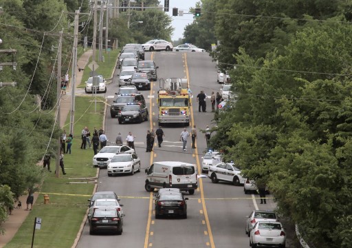 Police investigate a scene in Ballwin, Mo., Friday, July 8, 2016, after a Ballwin police officer was shot during a confrontation with a man on a street. Authorities say the wounded police officer is hospitalized didn't offer any immediate word about the officers medical status. A suspect is in custody, and a handgun has been recovered. (Cristina Fletes/St. Louis Post-Dispatch via AP)
