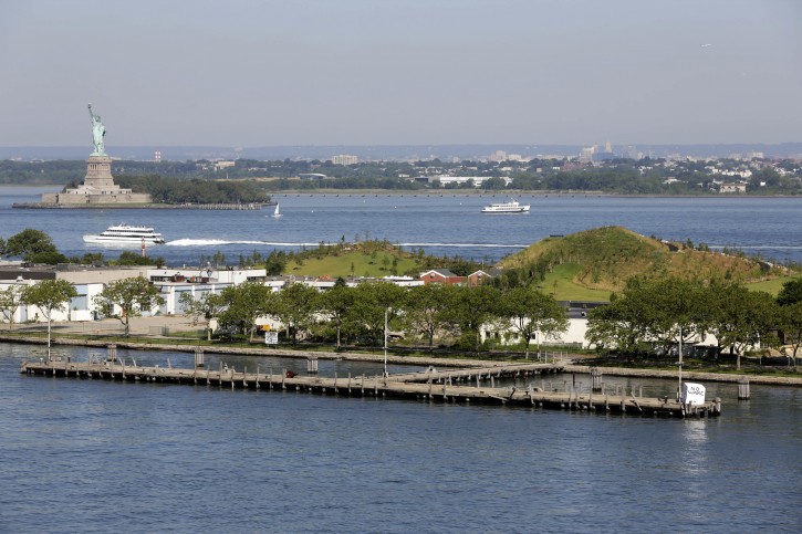 In this July 6, 2016 photo, two of the new  mounds are visible on Governors Island, in  New York Harbor. (AP Photo/Richard Drew)