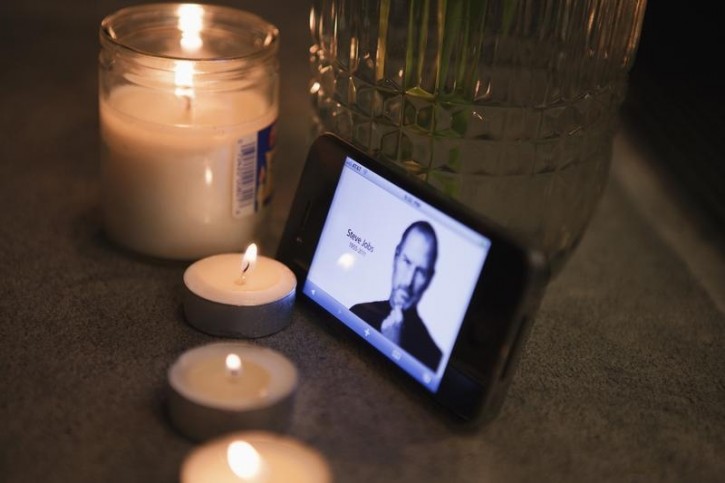 FILE - A bouquet of flowers, candles, and an iPhone form an impromptu shrine in front of the upper west side Apple Store in New York October 5, 2011.. Reuters