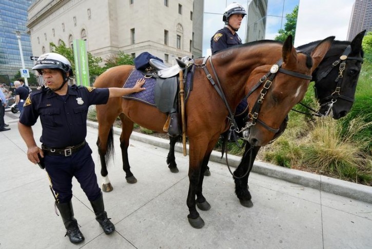 Cleveland mounted police officer Abraham Cortes leans on his horse Paco with fellow officer Michael Herrin (R) on Bas during a demonstration of police capabilities near the site of the Republican National Convention July 14, 2016. Reuters