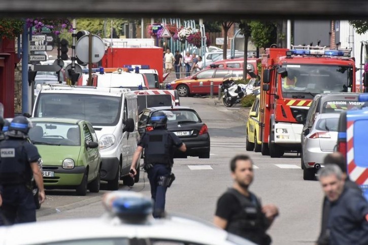 Police and rescue workers stand at the scene after two assailants had taken five people hostage in the church at Saint-Etienne-du -Rouvray near Rouen in Normandy, France, July 26, 2016. Two attackers killed a priest with a blade and seriously wounded another hostage in a church in northern France on Tuesday before being shot dead by French police.   REUTERS/Steve Bonet
