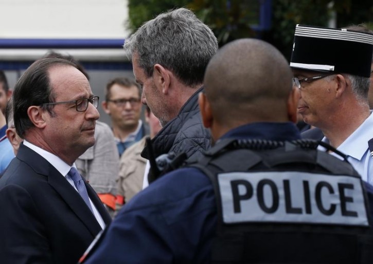 French President Francois Hollande (L) speaks with police forces after two assailants had taken five people hostage in the church at Saint-Etienne-du -Rouvray near Rouen in Normandy, France, July 26, 2016. REUTERS/Pascal Rossignol 