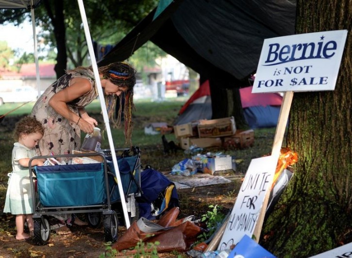 A supporter of Senator Bernie Sanders reorganizes her camp following Monday night's thunderstorm in Philadelphia, Pennsylvania, U.S., July 26, 2016. REUTERS/Bryan Woolston 