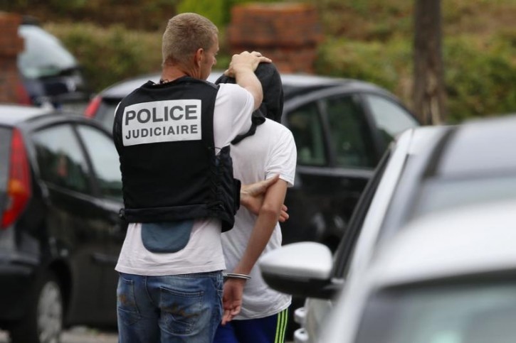 French judicial investigating police apprehends a man during a raid after a hostage-taking in the church in Saint-Etienne-du-Rouvray near Rouen in Normandy, France, July 26, 2016. A priest was killed with a knife and another hostage seriously wounded in an attack on a church that was carried out by assailants linked to Islamic State.  REUTERS/Pascal Rossignol