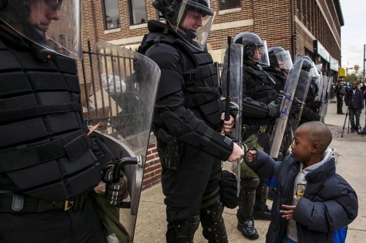 FILE - A young boy greets police officers in riot gear during a march in Baltimore, Maryland May 1, 2015 following the decision to charge six Baltimore police officers -- including one with murder -- in the death of Freddie Gray, a black man who was arrested and suffered a fatal neck injury while riding in a moving police van, the city's chief prosecutor said on Friday. REUTERS/Lucas Jackson/Files