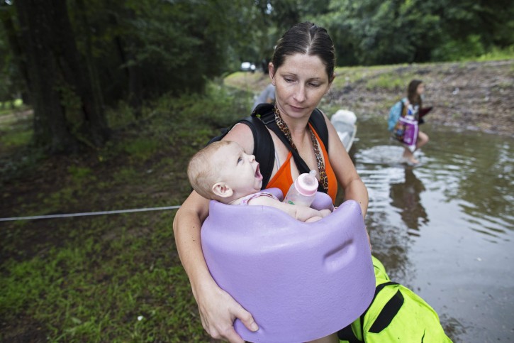 Danielle Blount carries her 3-month-old baby Ember to a truck from the Louisiana Army National Guard as they evacuate the area near Walker, La., after heavy rains inundated the region, Sunday, Aug. 14, 2016. (AP Photo/Max Becherer)