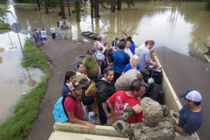 Sgt. Brad Stone of the Louisiana Army National Guard gives safety instructions to people loaded on a truck after they were stranded by rising floodwater near Walker, La., after heavy rains inundated the region, Sunday, Aug. 14, 2016. (AP Photo/Max Becherer)