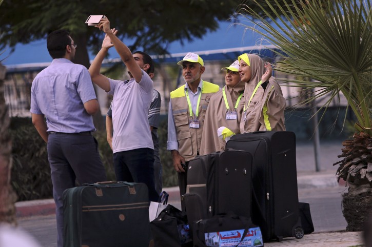 A Palestinian man takes photo with with his relatives before leaving for the annual hajj pilgrimage to the holy city of Mecca, in Gaza City, early Tuesday, Aug. 30, 2016. Hundreds of Palestinian pilgrims are leaving Gaza through the Rafah border crossing with Egypt on their way to Mecca, Saudi Arabia, for hajj. Egypt has agreed to keep the crossing open for three days to allow thousands of people to cross, heading to the Cairo International Airport. (AP Photo/Adel Hana)