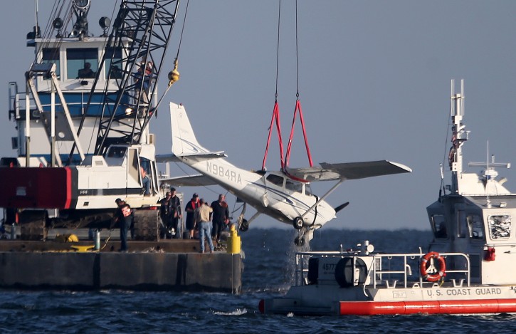 A small plane is lifted by a crane from the water of Lake Pontchartrain near Lakefront Airport, Tuesday, Aug. 30, 2016 in New Orleans.  New Orleans Fire Department spokesman Gregory Davis said the bodies of the pilot and a passenger were in the plane's cabin. A second passenger, a woman, survived Saturday night's crash when she was picked up a boat in the area. (Michael DeMocker/NOLA.com The Times-Picayune via AP)