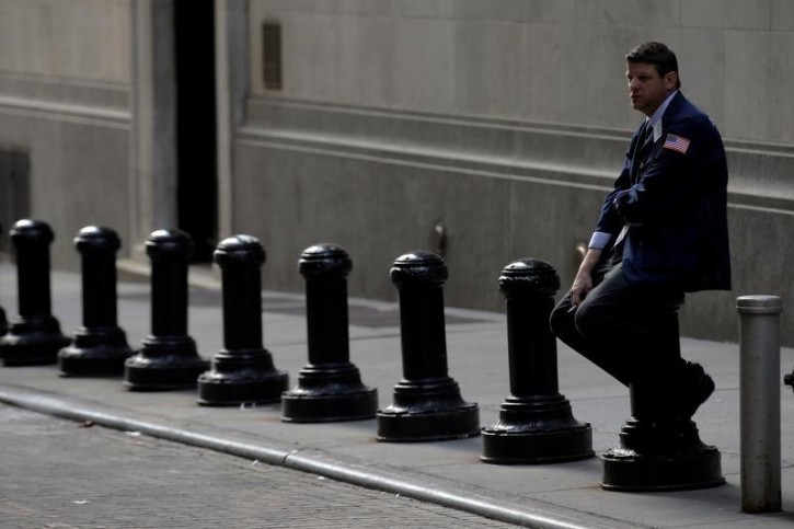 A trader takes a break outside the New York Stock Exchange (NYSE) on Wall Street in New York City, U.S., July 11, 2016.  REUTERS/Brendan McDermid 