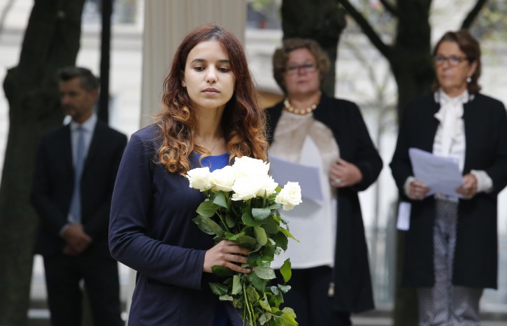 An unidentified relative of victims is to lay flowers during a ceremony for victims of terrorism in Paris, Monday Sept.19, 2016. French President Francois Hollande presides over a national ceremony to pay tribute to victims of terrorist attacks including that targeting Nice on Bastille Day. (AP Photo/Michel Euler, Pool)