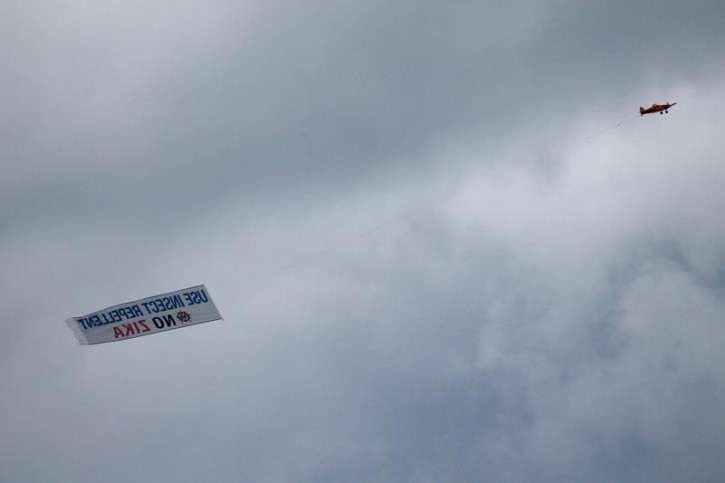 An airplane carrying a banner asking people to use insect repellent to avoid the Zika virus, flies over Miami, Florida, U.S., September 13, 2016. REUTERS/Carlo Allegri
