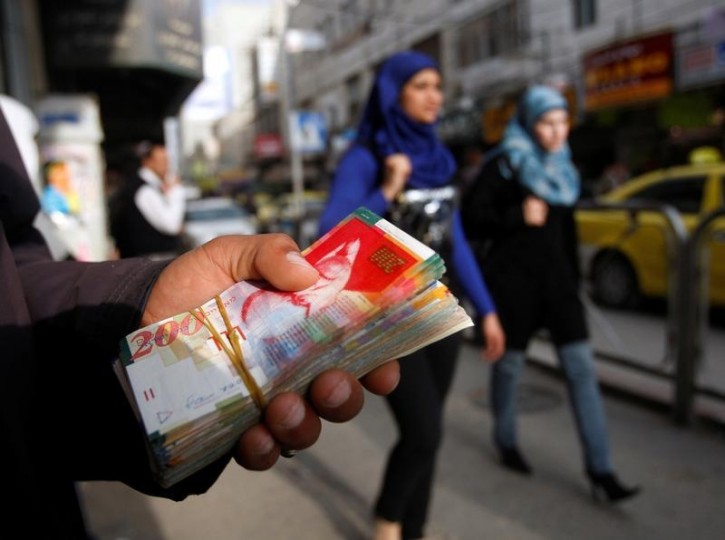 FILE - Palestinian women walk past a money changer in the West Bank city of Ramallah February 16, 2010. REUTERS/Mohamad Torokman/File Photo
