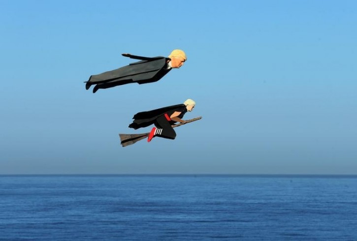 Remote control planes resembling U.S. Presidential candidate Donald Trump and Hillary Clinton fly over surfers in Carlsbad, California, U.S. September 15, 2016. REUTERS/Mike Blake