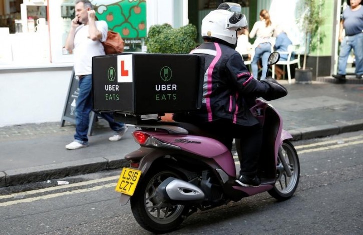 An UberEATS food delivery courier rides her scooter in London, Britain September 7, 2016. Picture taken September 7, 2016. REUTERS/Neil Hall