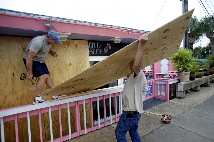 Tim Allen, left, and Joe Allen board up the front of an outdoor bar as they prepare for Tropical Storm Hermine Thursday, Sept. 1, 2016, in Cedar Key, Fla. (AP Photo/John Raoux)