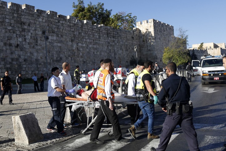 Members of a ZAKA emergency response team and emergency paramedics evacuate a wounded Palestinian attacker from the scene after he reportedly stabbed two Israeli police officers with a knife near the Damascus Gate in the Old City district of Jerusalem, 19 September 2016. EPA