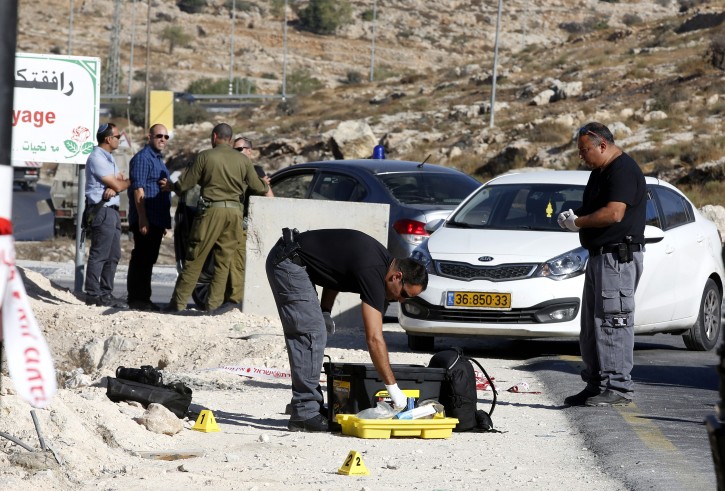 An Israeli policeman secures evidence at the scene of what the Israeli Army claims was a stabbing attack by a 16-years old Palestinian, whom they identified as Issa Abed Soboh, outside the West Bank village of Bani Naem, near Hebron, 20 September 2016. EPA