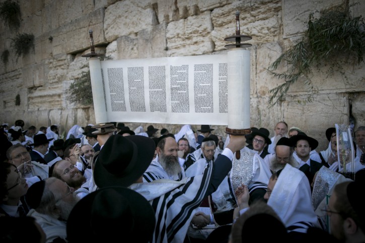 A Jewish lifts a Torah scroll as he takes part in the Hoshana Rabbah pray, (on the seventh day of Sukkot) in Jerusalem Western Wall on October 23, 2016. Photo by Yonatan Sindel/Flash90 