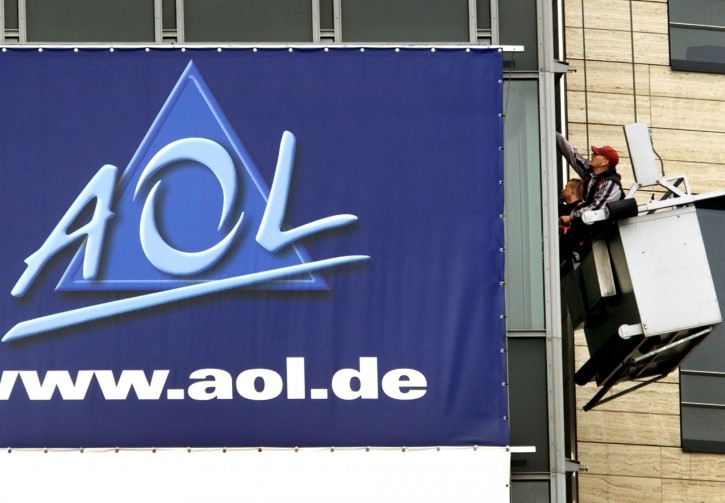 FILE - In this March 17, 2000, file photo, window cleaners work at the front of the headquarters of AOL Europe in Hamburg, Germany.  (AP Photo/Michael Probst, File)