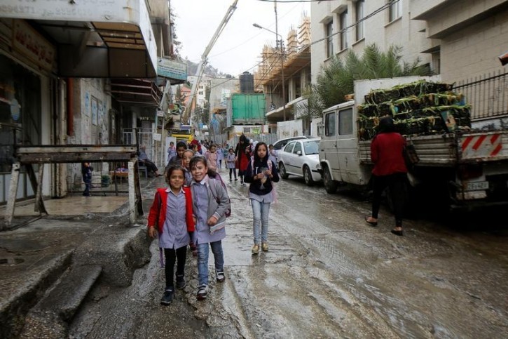 Palestinian school girls walk to their homes on a rainy day in Balata refugee camp near the West Bank city of Nablus November 1, 2016. Picture taken November 1, 2016. REUTERS/Abed Omar Qusini 