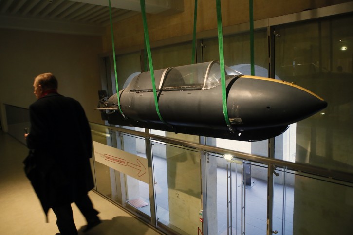 A visitor walks by a 1970 real submarine used by the French secret agents as real-life spy gadgets of secret agents around the world are displayed at the 'Secret Wars' exhibition in Invalides War Museum, in Paris, Monday, Dec. 12, 2016. 'Secret Wars' displays about 400 objects, devices and archives from World War I to the end of the Cold War of French, British, American and German collections, most of which have never been shown before. (AP Photo/Francois Mori)
