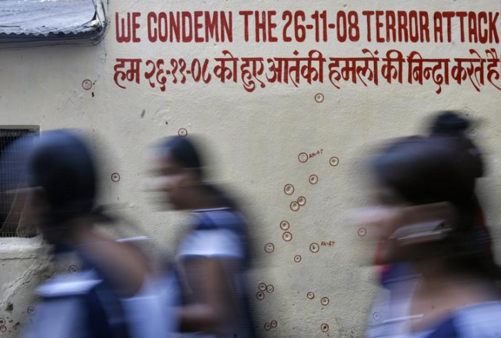 FILE - Schoolgirls walk past a wall riddled with bullet holes at the Chabad House in Mumbai November 24, 2009. Reuters