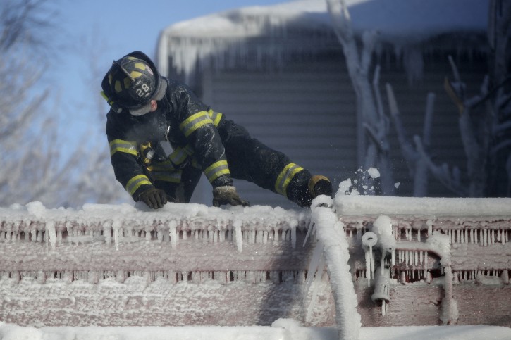 - In a photo from Friday, Jan. 5, 2018, a Newark firefighter kicks free a hose frozen onto a roof of a building after helping battle a five building fire in Newark, N.J. Firefighters battling blazes in the extreme cold are faced with treacherous conditions, frozen hydrants and slick surfaces that make an already difficult job even harder. Departments in colder climates prepare months ahead for the coming freeze _ readying equipment and changing how they approach fires in the coldest months. (AP Photo/Julio Cortez)