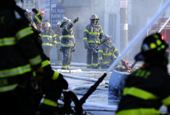 FILE- In this Jan. 2, 2018 file photo, firefighters are covered with ice from water sprayed from their hoses as they work to contain a fire in the Bronx section of New York. Firefighters battling blazes in the extreme cold are faced with treacherous conditions that can slow them down when every second counts. (AP Photo/Seth Wenig, File)