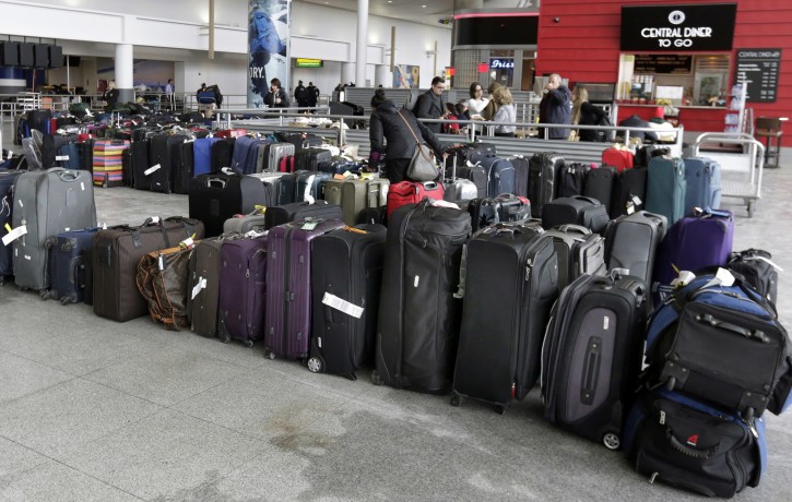 FILE - In this Jan. 8, 2018, file photo, unclaimed baggage sits at New York's John F. Kennedy Airport after a water pipe burst following several days of weather-related delays in the wake of a powerful winter storm. Over a week after winter weather woes snowballed into a long weekend of dysfunction at the airport, some passengers are still waiting for their baggage. The still-missing luggage is a fraction of the thousands of unclaimed bags that accumulated during the chaos. (AP Photo/Richard Drew, File)