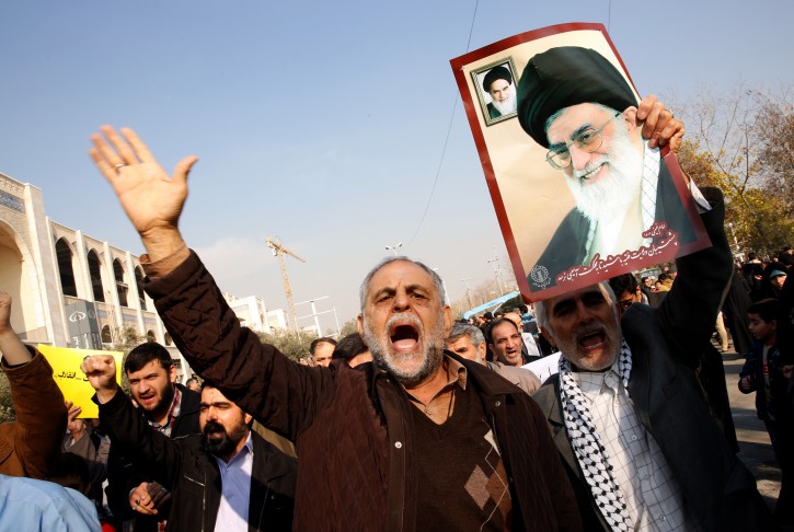 epa06418296 Iranians hold a portrait of Iranian Supreme Leader Ayatollah Ali Khamenei and take part  during a pro-government demonstration after the Friday prayer ceremony at the Imam Khomeini mosque in Tehran, Iran, 05 January 2018. EPA