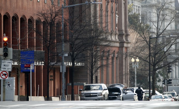 Police are seen searching a suspicious vehicle near the White House, Wednesday, Feb. 21, 2018 in Washington. The Secret Service said the New Executive Office Building, left, was evacuated and a portion of 17th Street had been closed to vehicle traffic. (AP Photo/Jacquelyn Martin)