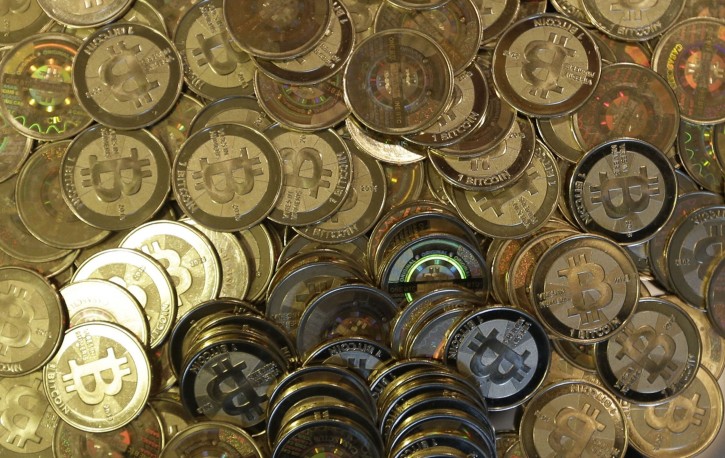 FILE - This April 3, 2013 file photo shows bitcoin tokens at a shop in Sandy, Utah. A new report warns central banks should carefully weigh the risks before introducing virtual currencies using the technology that enables bitcoin.(AP Photo/Rick Bowmer, file)