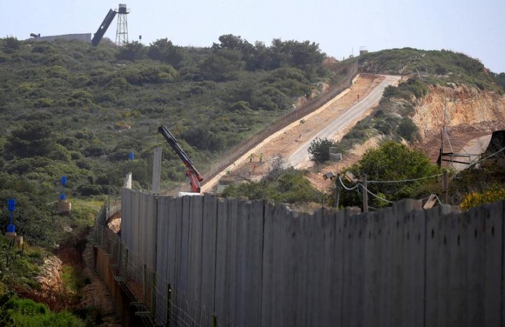 FILE - An Israeli crane builds a wall near the border, seen from Lebanon, near the village of Naqoura, March 6, 2018. Picture taken March 6, 2018. REUTERS/Ali Hashisho