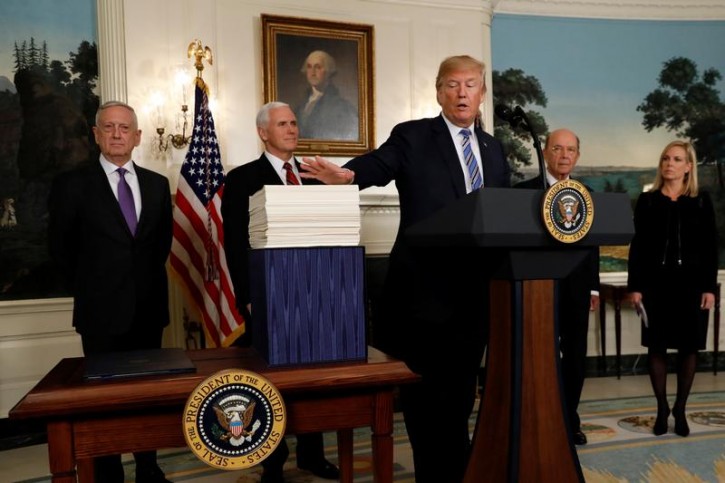 U.S. President Donald Trump gestures towards Congress' $1.3 trillion spending bill, during a signing ceremony, in the Diplomatic Room of the White House in Washington, D.C., U.S., March 23, 2018. REUTERS/Kevin Lamarque 