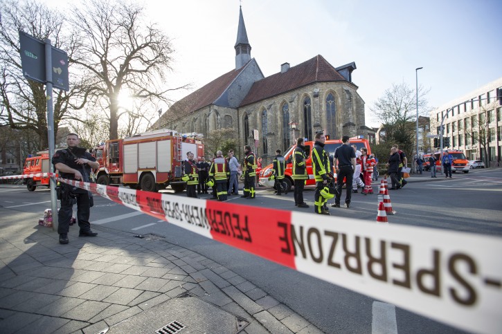Police walk in downtown Muenster, Germany, Saturday, April 7, 2018.  A vehicle crashed into a crowd Saturday in the western German city of Muenster, killing three people and injuring 20 others. The German news agency dpa has quoted police as saying the driver of that car in Muenster has killed himself.  (Friso Gentsch/dpa via AP)