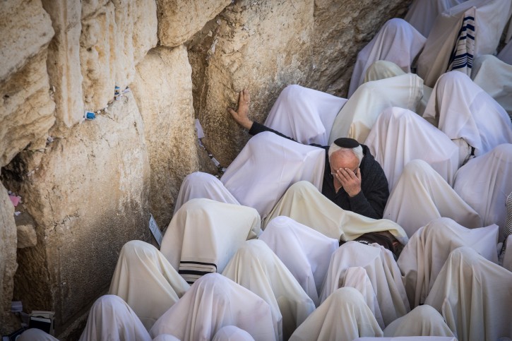 Jewish worshippers cover themselves with prayer shawls as they pray in front of the Western Wall, Judaism's holiest prayer site, in Jerusalem's Old City, during the Cohen Benediction priestly blessing at the Jewish holiday of Passover which commemorates the Israelites' hasty departure from Egypt. April 02, 2018. Photo by Noam Revkin Fenton/Flash90